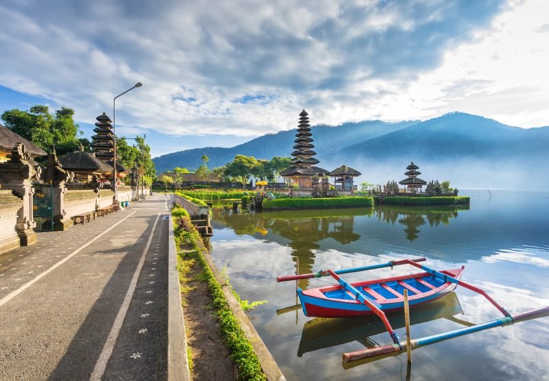 Pura Ulun Danu Bratan, floating temple with local boat in fore ground, Famous Hindu temple on Bratan lake in Bali, Indonesia.