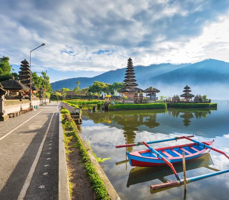 Pura Ulun Danu Bratan, floating temple with local boat in fore ground, Famous Hindu temple on Bratan lake in Bali, Indonesia.
