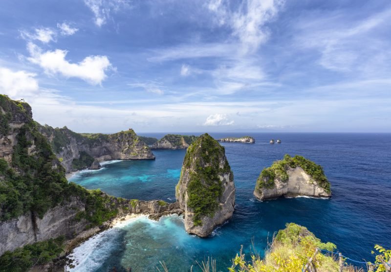 Blue sky over beautiful blue waters of the Raja Lima islands just off the coast of Nusa Penida, Indonesia.