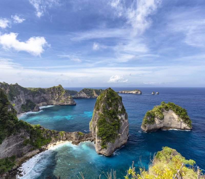 Blue sky over beautiful blue waters of the Raja Lima islands just off the coast of Nusa Penida, Indonesia.