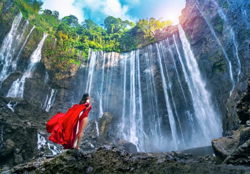 Young,Woman,Standing,At,Air,Tumpak,Sewu,Waterfall,,Indonesia.