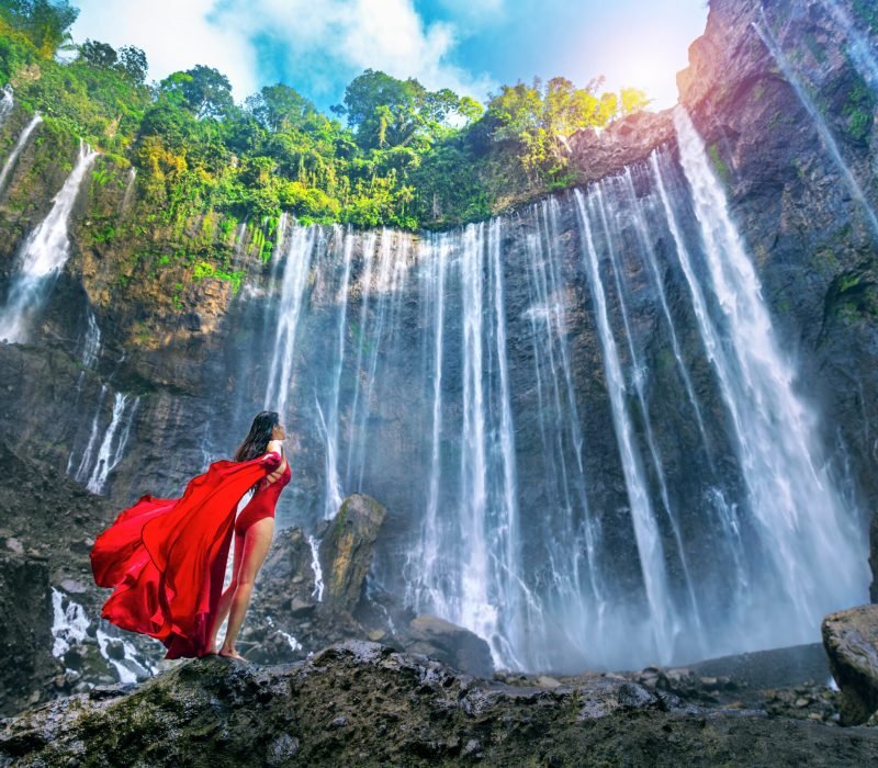 Young,Woman,Standing,At,Air,Tumpak,Sewu,Waterfall,,Indonesia.